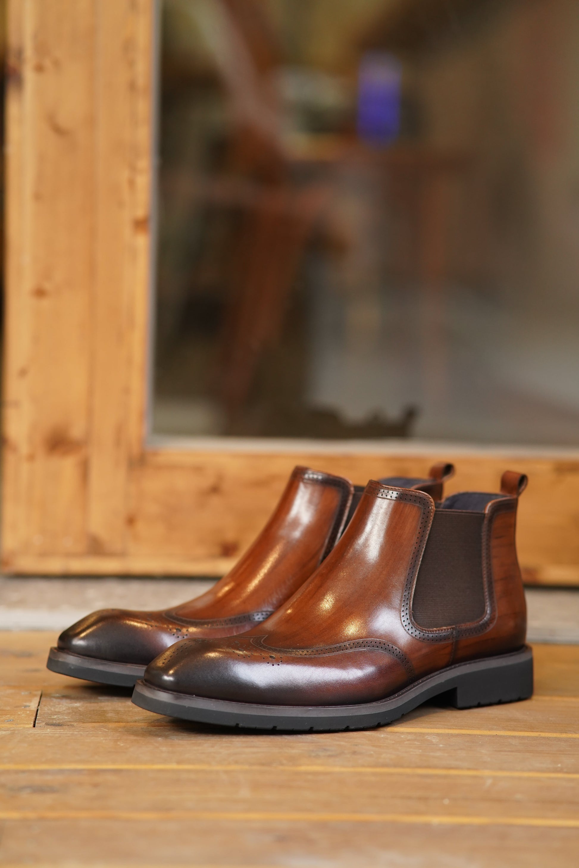 Cognac Brogue Spectator Chelsea Boots in polished brown leather with intricate brogue detailing for a refined look.