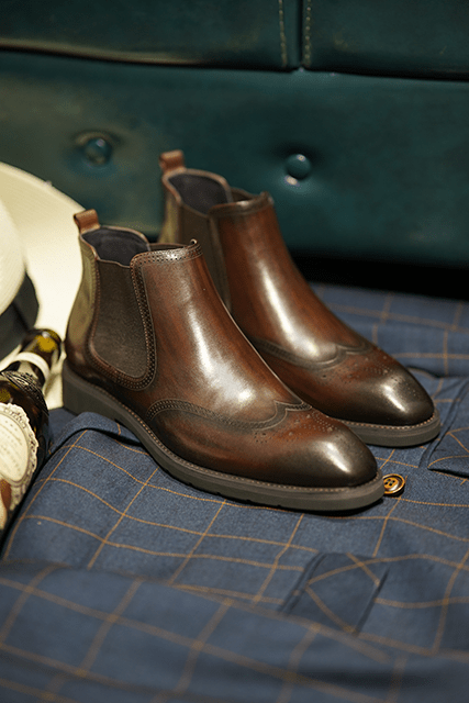 Cognac Brogue Spectator Chelsea Boots in polished brown leather with intricate brogue detailing for a refined look.