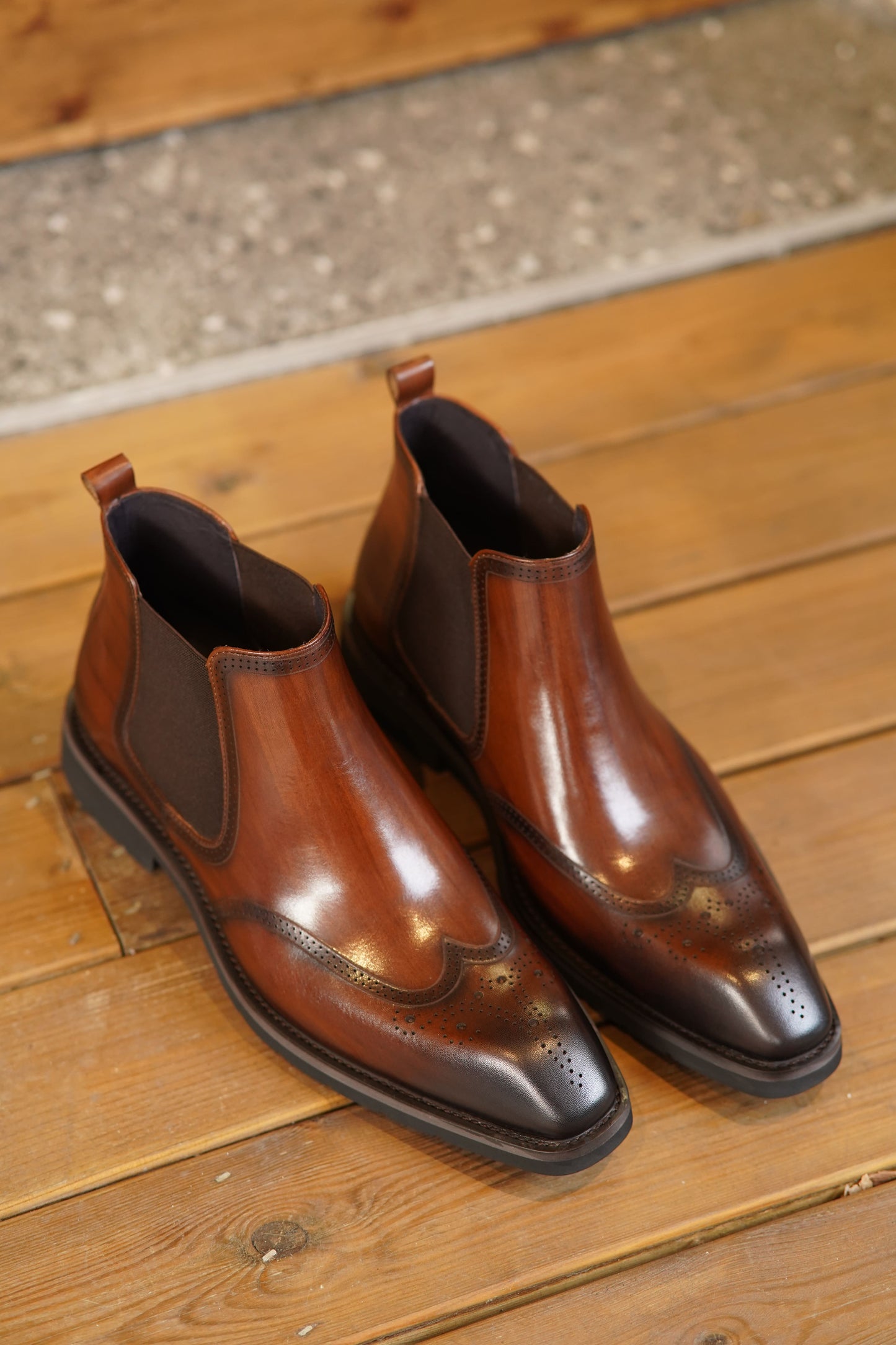 Cognac Brogue Spectator Chelsea Boots in polished brown leather with intricate brogue detailing for a refined look.