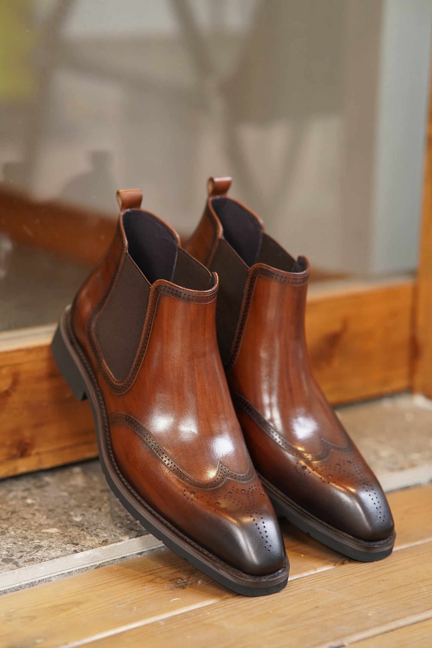 Cognac Brogue Spectator Chelsea Boots in polished brown leather with intricate brogue detailing for a refined look.