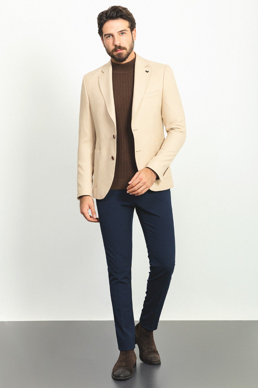 Full body view of the model in the Eiffel Beige Jacket, styled with a brown turtleneck and navy trousers, exuding modern elegance.