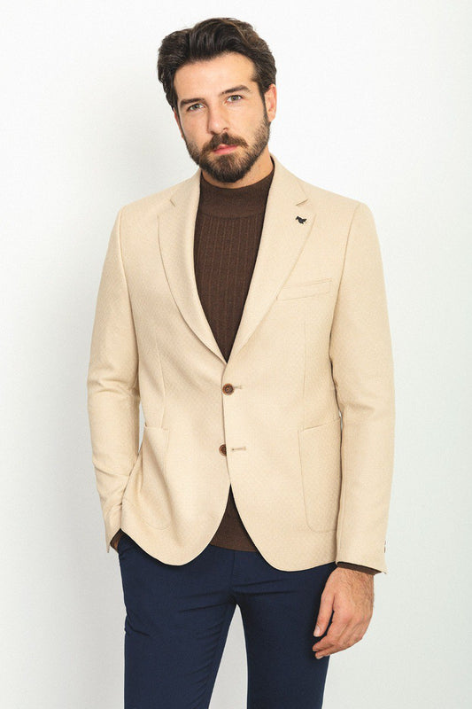 Model wearing the Eiffel Beige Jacket paired with a brown turtleneck sweater and navy trousers. The jacket features a slim fit with two buttons and flap pockets.