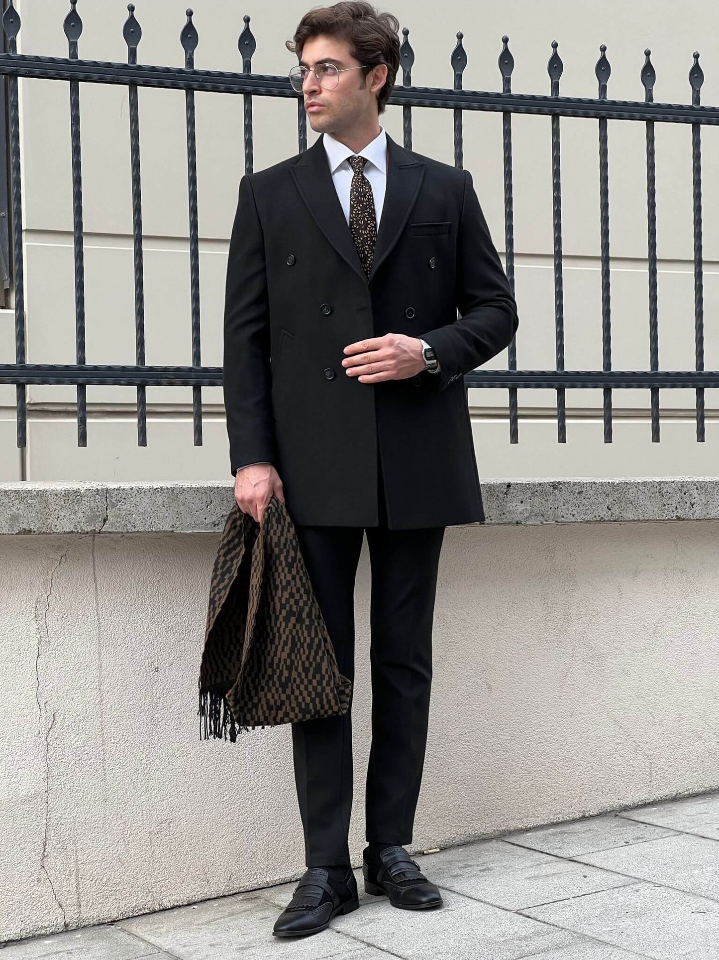 Elegance in motion: our male model effortlessly rocks the classic black coat.