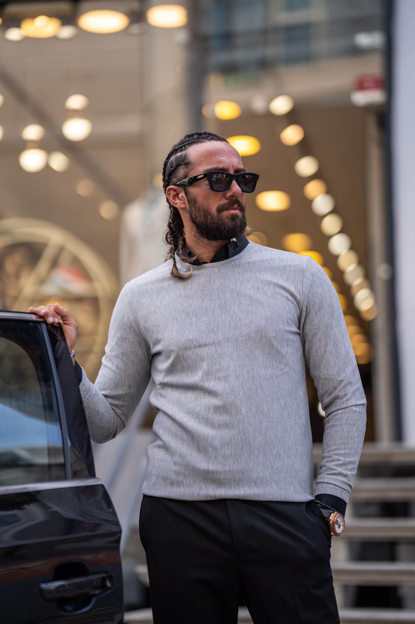 A stylish male model confidently displays our classic gray crewneck, showcasing its timeless appeal.