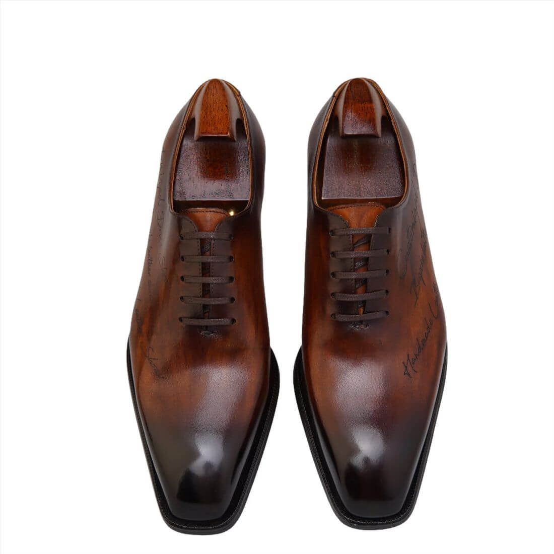 Elegant pair of handcrafted chestnut brown patina oxford shoes displayed on a wooden surface in a luxurious setting, surrounded by shoe care tools and accessories.