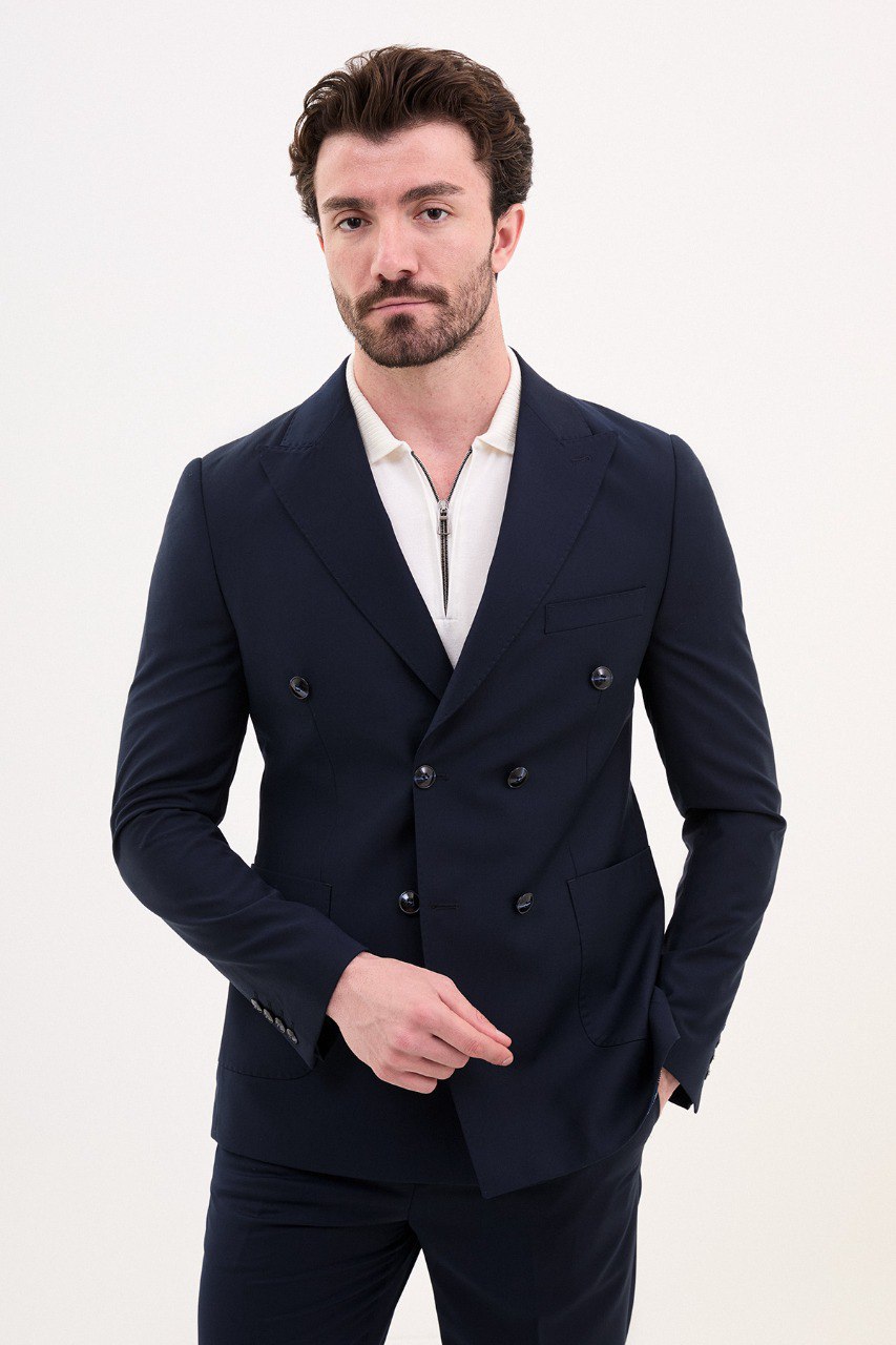 Model wearing a double-breasted navy blue suit from HolloMen’s Spring Summer Collection, showcasing refined tailoring and timeless elegance.