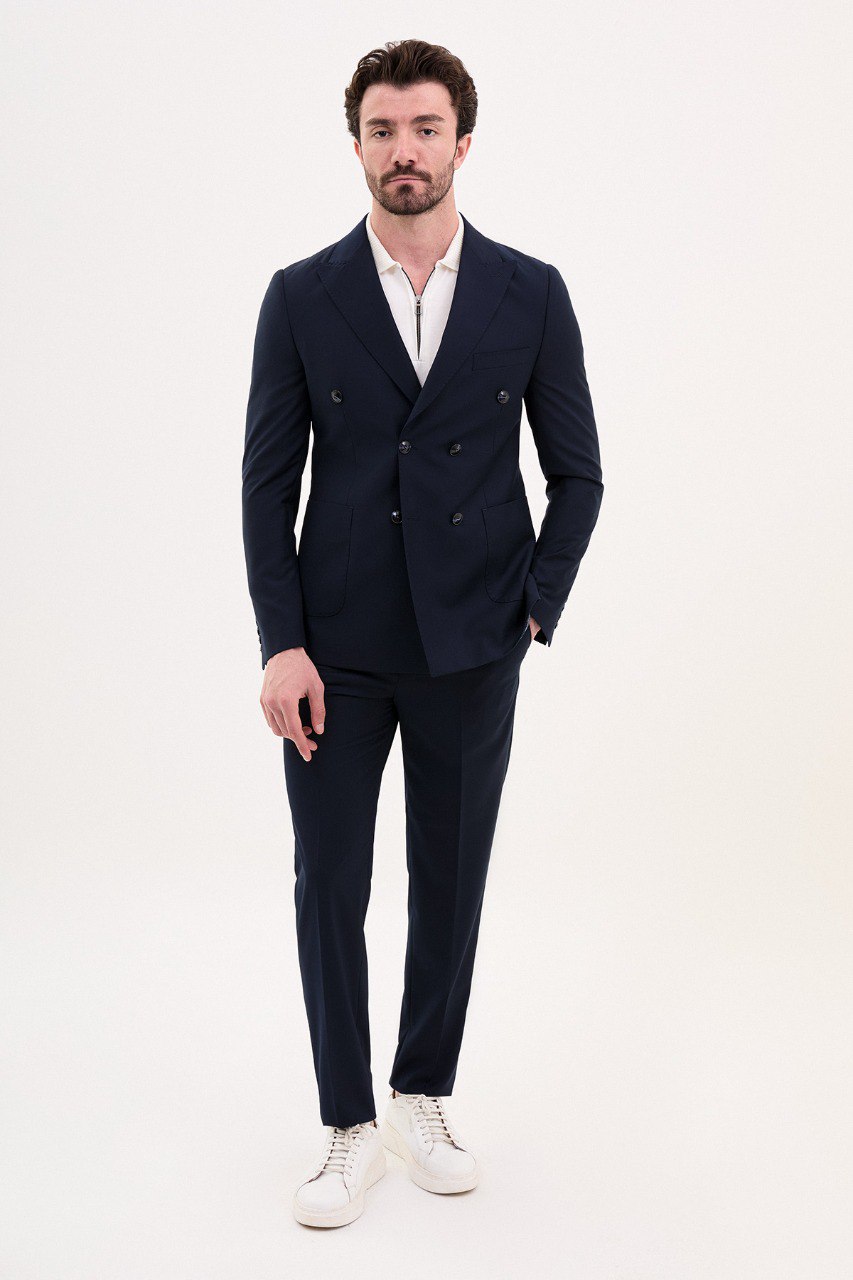 Model wearing a double-breasted navy blue suit from HolloMen’s Spring Summer Collection, showcasing refined tailoring and timeless elegance.