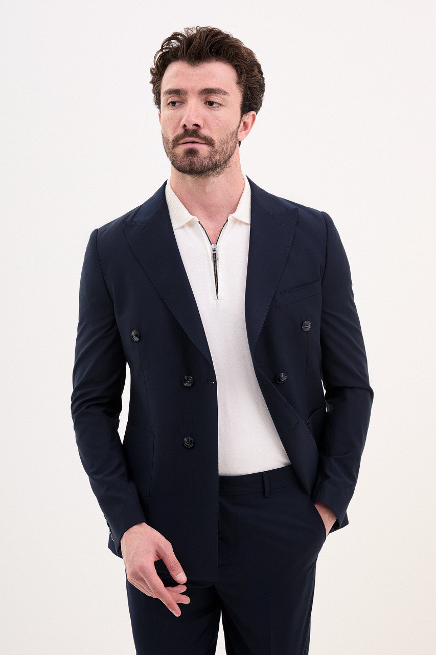 Model wearing a double-breasted navy blue suit from HolloMen’s Spring Summer Collection, showcasing refined tailoring and timeless elegance.