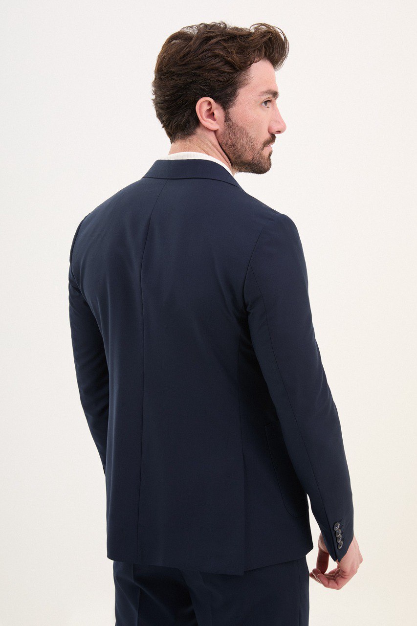 Model wearing a double-breasted navy blue suit from HolloMen’s Spring Summer Collection, showcasing refined tailoring and timeless elegance.