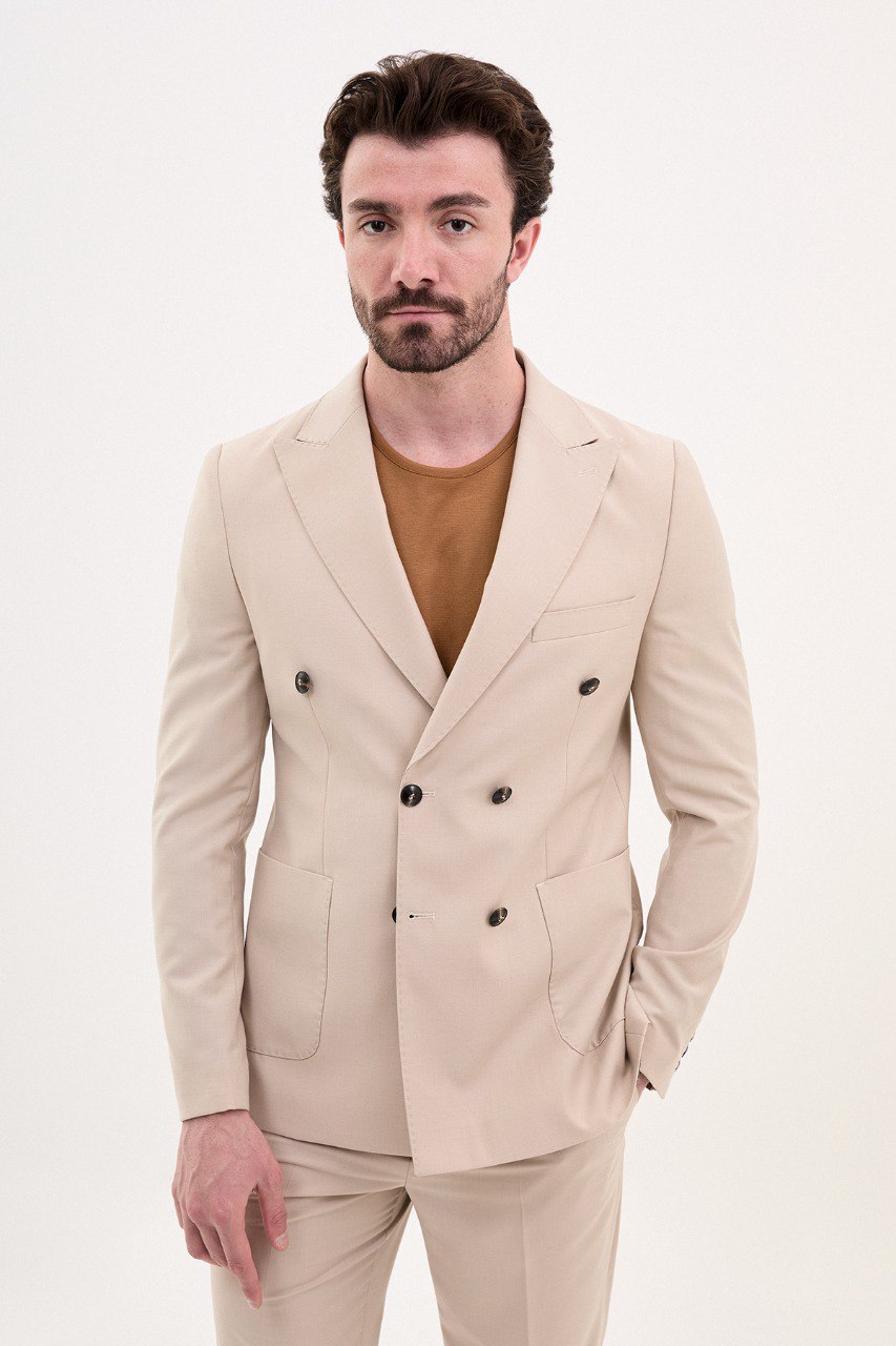 Man wearing a double-breasted beige suit with a casual brown shirt from HolloMen’s Spring Summer Collection.