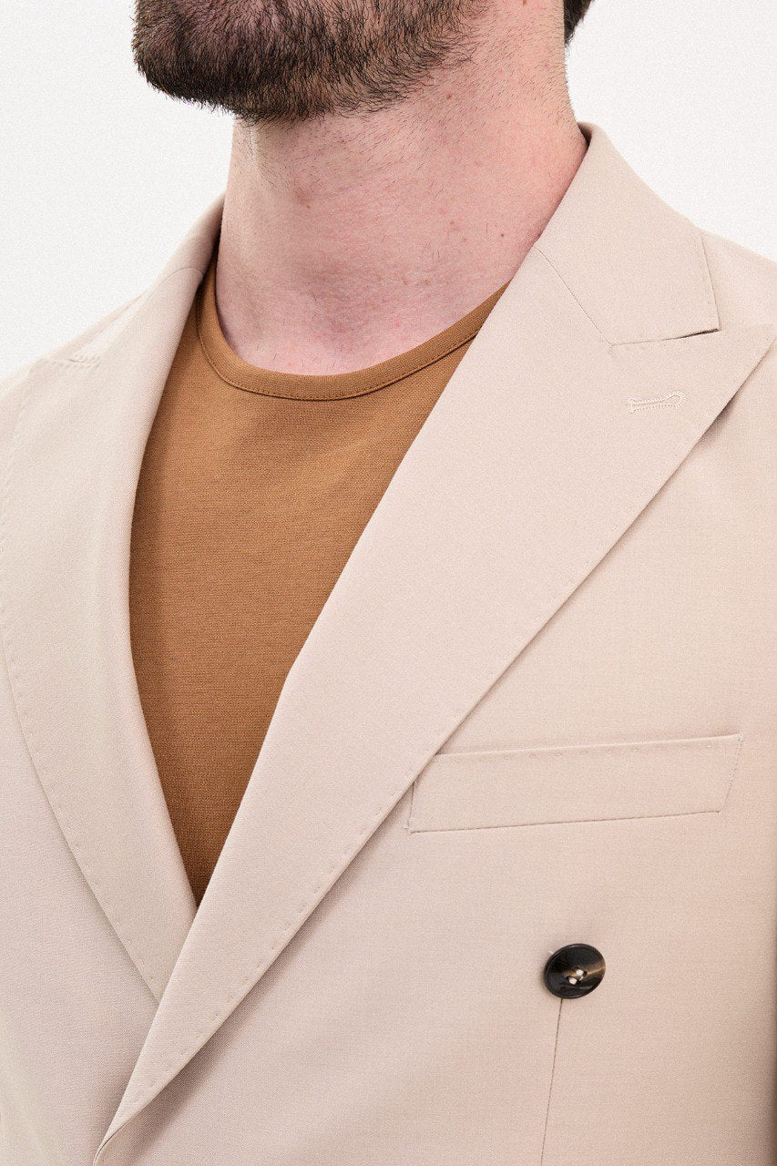 Man wearing a double-breasted beige suit with a casual brown shirt from HolloMen’s Spring Summer Collection.