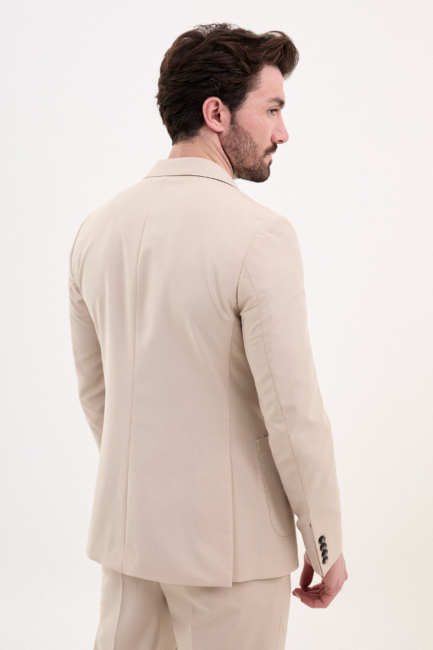 Man wearing a double-breasted beige suit with a casual brown shirt from HolloMen’s Spring Summer Collection.