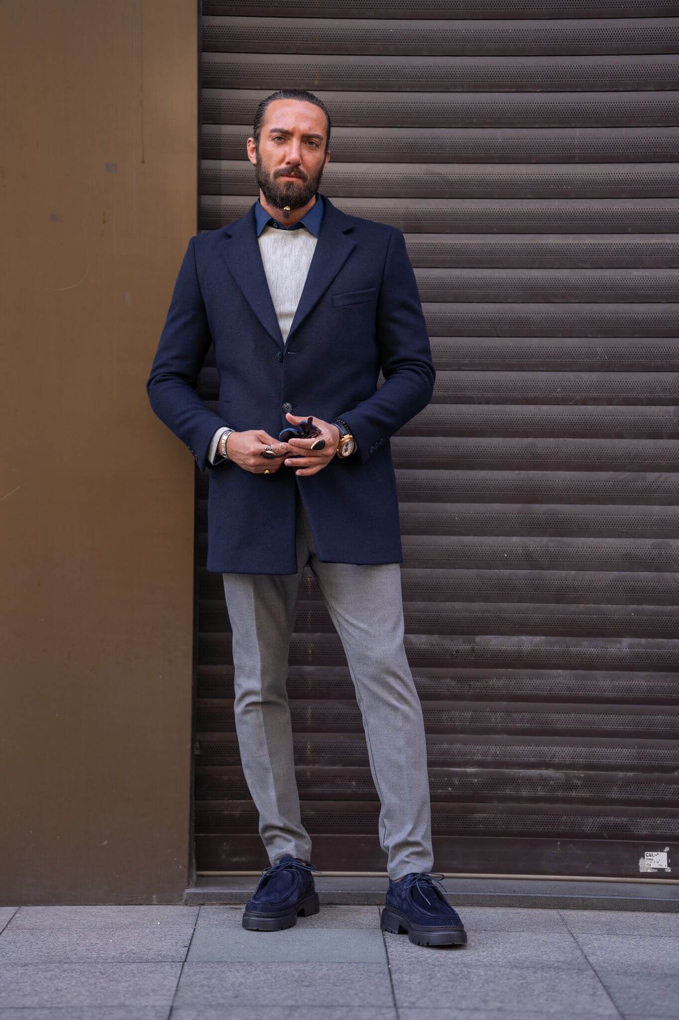 Confident male model exudes sophistication in our impeccably tailored navy blue coat.