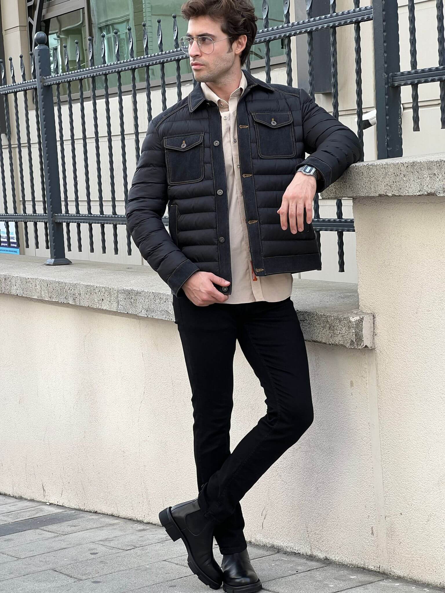 Stylish male model confidently wears a sleek black denim coat, exuding urban cool vibes.